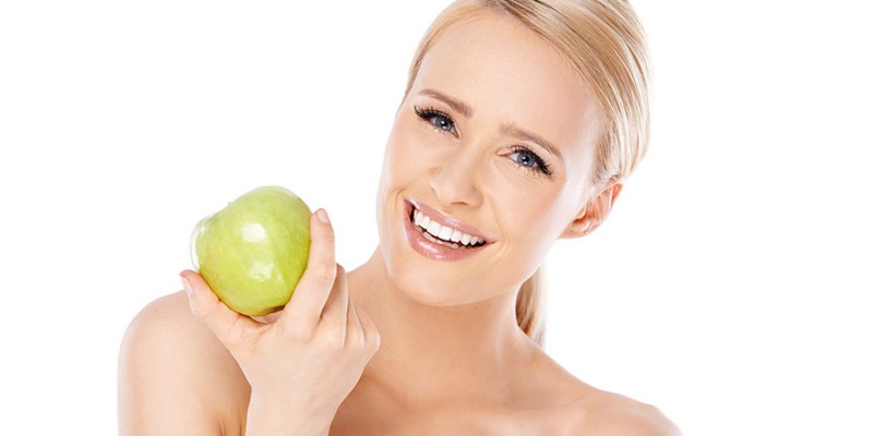 Adorable and healthy woman holding apple